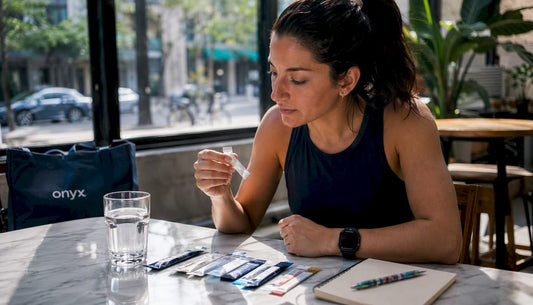 Woman reviewing supplement strips at kitchen table