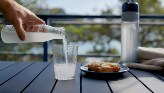 Close-up pouring electrolyte drink with toast and banana