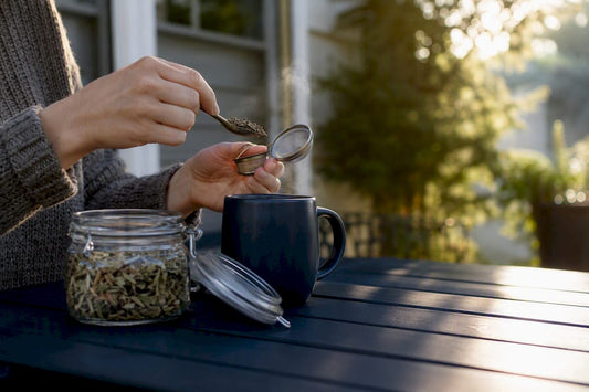 Hands preparing herbal tea on kitchen counter