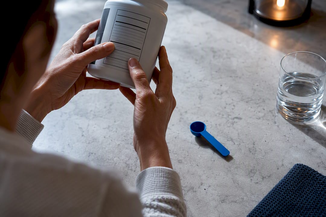 Hands inspecting a supplement facts panel